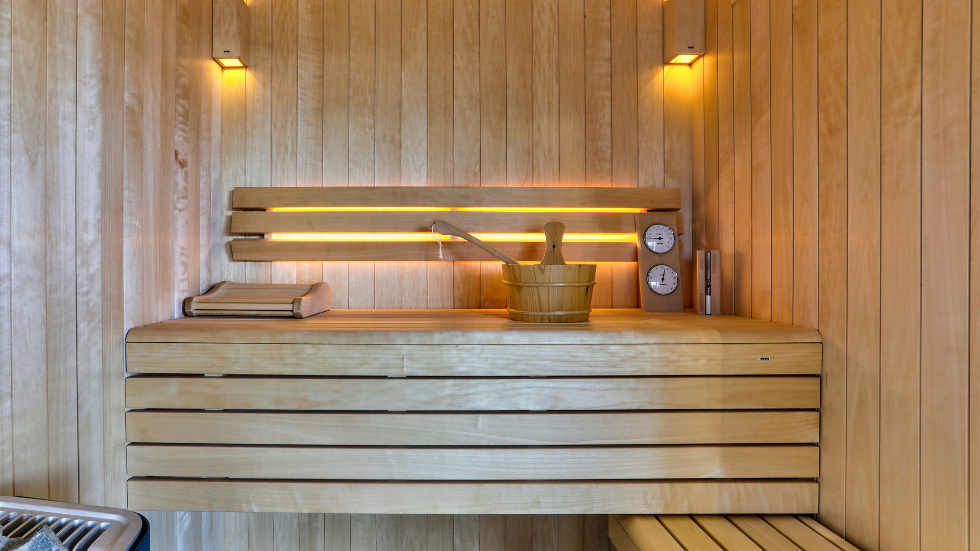 Intérieur de sauna en bois avec seau, louche et éclairage LED chaleureux